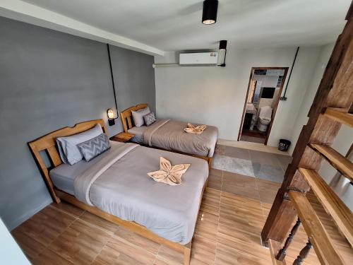 a bedroom with two beds and a mirror at The Seasons At Pai in Pai