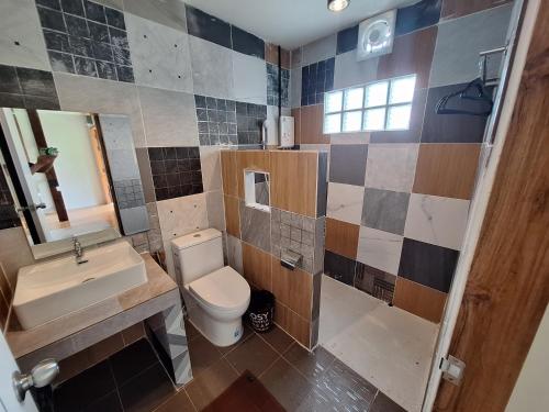 a bathroom with a toilet and a sink and a mirror at The Seasons At Pai in Pai