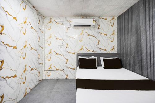 a bedroom with a bed and a stone wall at Hotel O Kadodara Surat Sanjivani Hospital Formerly Rolex in Balesar