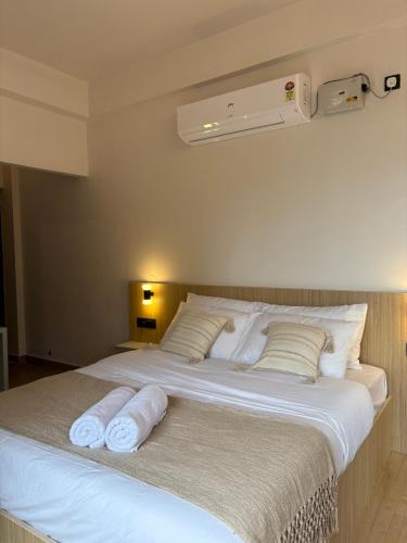 a bedroom with a large bed with towels on it at Thira House in Varkala