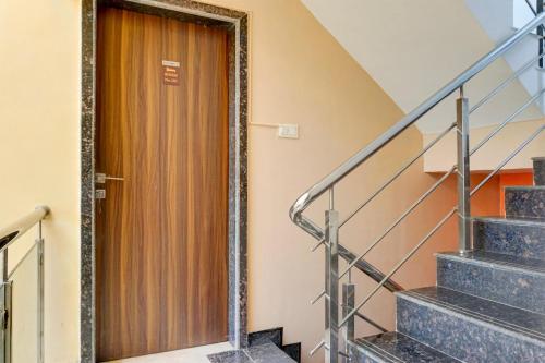 a wooden door in a building with stairs at Super Collection O Khatri Park Formerly Aum Villa in Lonavala