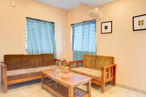 a living room with two couches and a coffee table at Super Collection O Khatri Park Formerly Aum Villa in Lonavala