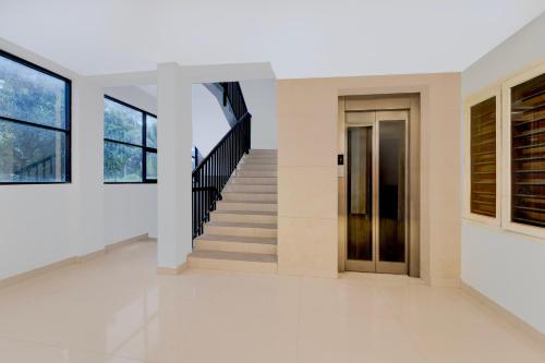 a hallway of a building with stairs and a door at Super Townhouse Thondayad Calicut Formerly Dream Casa in Kakkayam