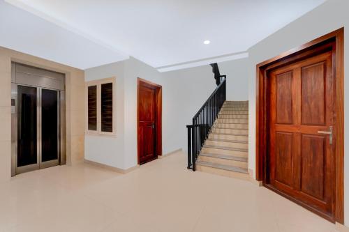 a room with a staircase and a wooden door at Super Townhouse Thondayad Calicut Formerly Dream Casa in Kakkayam