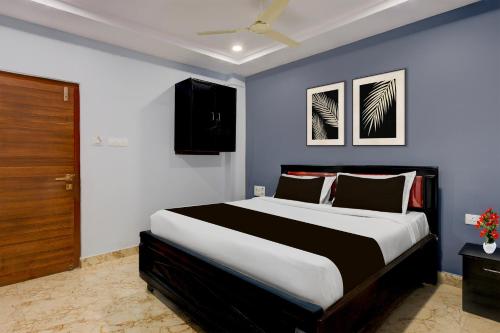 a bedroom with a large bed with blue walls at Super Collection O Dr. NTR University Of Health Sciences Formerly Hotel V Elite in Vijayawāda