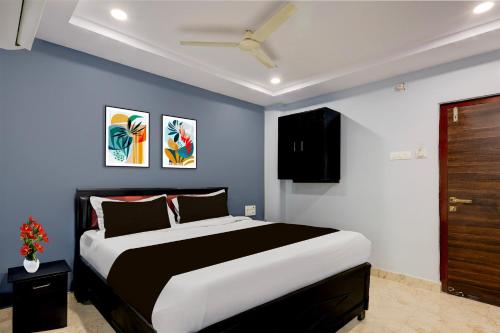 a bedroom with a large bed with blue walls at Super Collection O Dr. NTR University Of Health Sciences Formerly Hotel V Elite in Vijayawāda