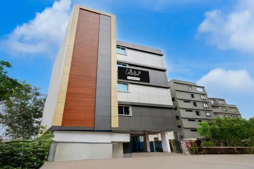 a tall building with a sign on it at Super Collection O Dr. NTR University Of Health Sciences Formerly Hotel V Elite in Vijayawāda