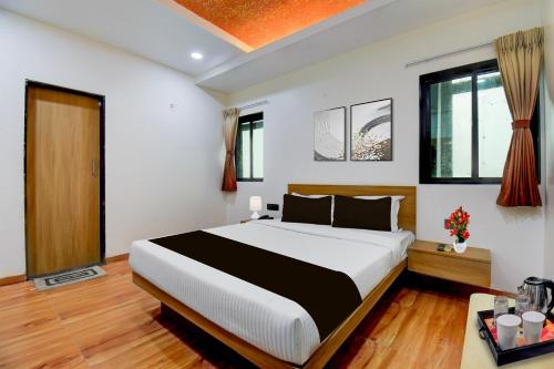 a bedroom with a large bed in a room at Super Townhouse Balewadi Stadium Pune Formerly Hotel Sarovar in Pune