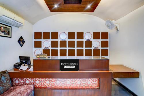 a hotel reception desk in a room with clocks on the wall at Townhouse Madan Mahal Railway Junction Formerly Annpurna Inn in Jabalpur