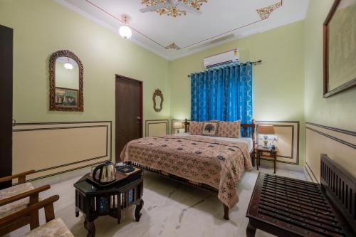 a bedroom with a bed with a blue curtain at Rajasthan Palace - A Heritage Boutique Hotel in Jaipur in Jaipur