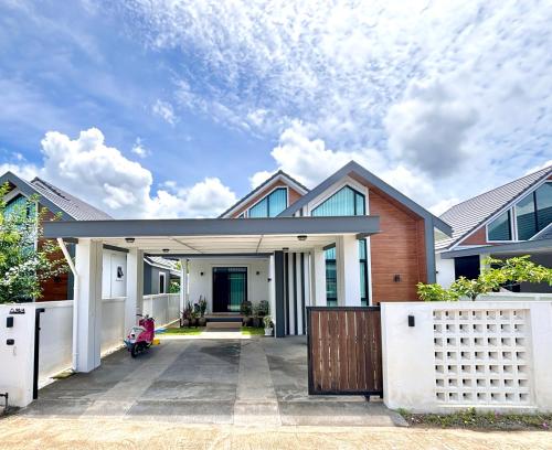a house with a garage and a fence at D sleep Villa Chiangmai in Chiang Mai