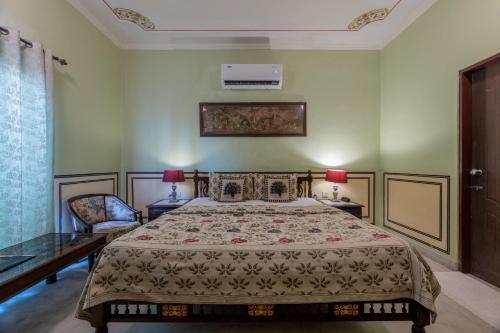 a bedroom with a large bed and two chairs at Rajasthan Palace - A Heritage Boutique Hotel in Jaipur in Jaipur