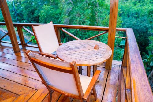 a wooden table and two chairs on a deck at Villa Vanilla in Port Glaud