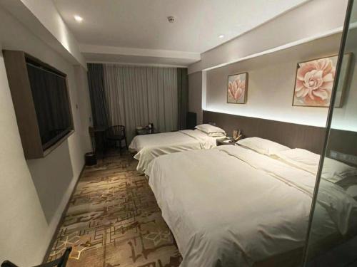 a hotel room with three beds and a window at New Friendship Hotel in Luoyang