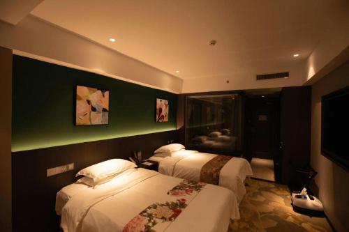 a hotel room with two beds and a television at New Friendship Hotel in Luoyang