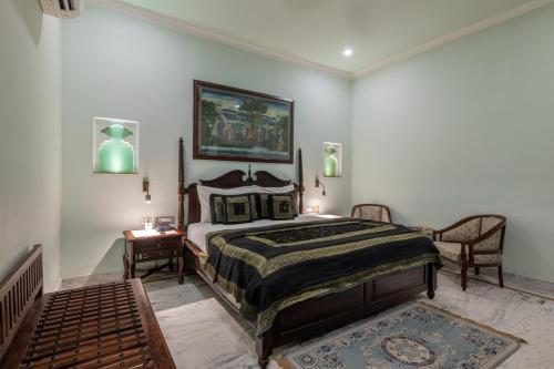 a bedroom with a bed and a table and chairs at Rajasthan Palace - A Heritage Boutique Hotel in Jaipur in Jaipur