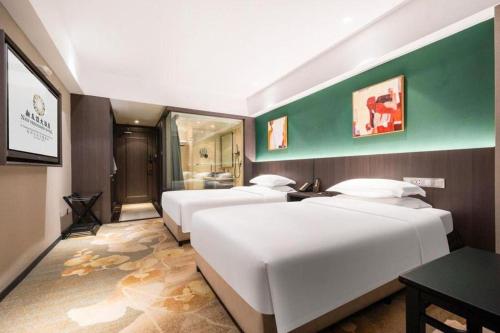a bedroom with three beds and a green wall at New Friendship Hotel in Luoyang