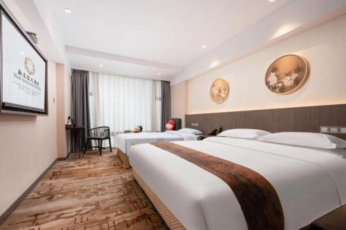 a hotel room with two beds and a television at New Friendship Hotel in Luoyang