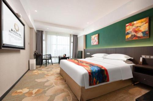 a bedroom with a large bed and a flat screen tv at New Friendship Hotel in Luoyang