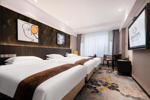 a hotel room with a row of beds and a television at New Friendship Hotel in Luoyang