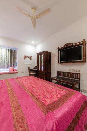 a bedroom with a large pink bed and a flat screen tv at Rajasthan Palace - A Heritage Boutique Hotel in Jaipur in Jaipur