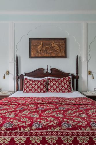 a bedroom with a large bed with red pillows at Rajasthan Palace - A Heritage Boutique Hotel in Jaipur in Jaipur