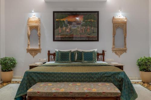 a bedroom with a bed with a green bedspread and two mirrors at Rajasthan Palace - A Heritage Boutique Hotel in Jaipur in Jaipur