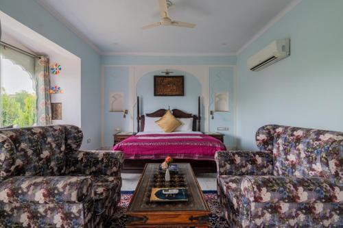 a living room with two chairs and a bed at Rajasthan Palace - A Heritage Boutique Hotel in Jaipur in Jaipur