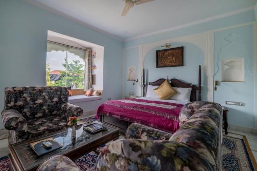 a bedroom with a bed and a couch and a table at Rajasthan Palace - A Heritage Boutique Hotel in Jaipur in Jaipur