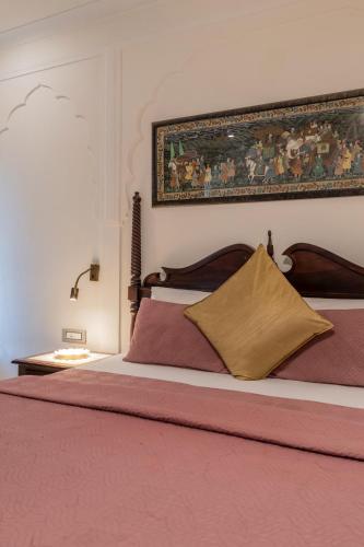 a bedroom with a bed with a painting on the wall at Rajasthan Palace - A Heritage Boutique Hotel in Jaipur in Jaipur