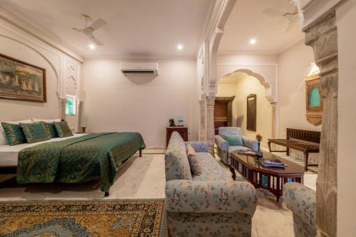 a bedroom with a bed and a couch and a table at Rajasthan Palace - A Heritage Boutique Hotel in Jaipur in Jaipur