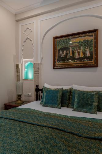 a bedroom with a bed with a painting on the wall at Rajasthan Palace - A Heritage Boutique Hotel in Jaipur in Jaipur