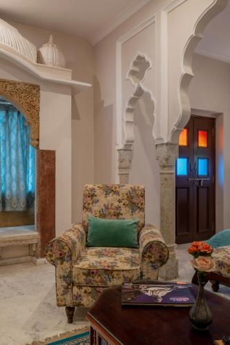 a living room with a chair and a table at Rajasthan Palace - A Heritage Boutique Hotel in Jaipur in Jaipur
