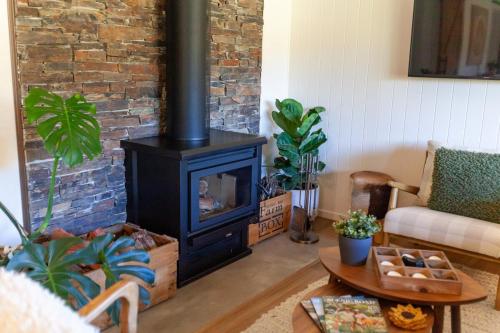 a living room with a wood stove in a room at Gumtop - Luxury Farmhouse Cabin in Bunburra