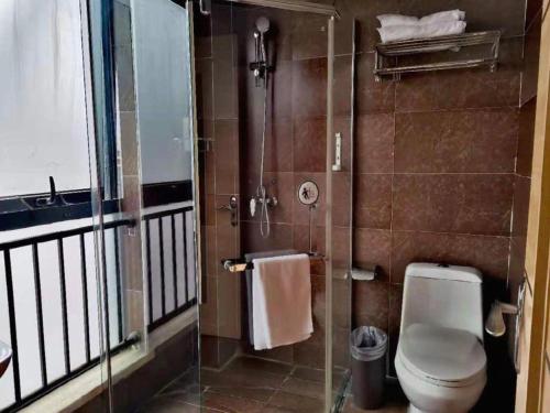 a bathroom with a toilet and a glass shower at IU Hotel Chengdu High-Tech Zone Longhu Times Street in Chengdu
