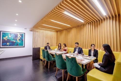a group of people sitting at a table in a restaurant at FabHotel Prime Kzar Corporate Budget Stay Near Park Street in Kolkata