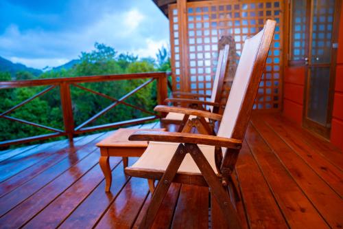 a pair of chairs sitting on a wooden deck at Villa Vanilla in Port Glaud