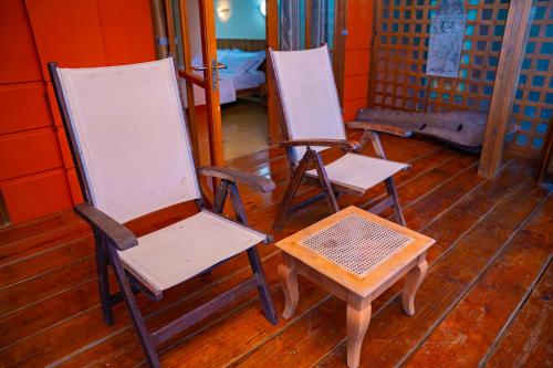 three chairs and a table in a room at Villa Vanilla in Port Glaud