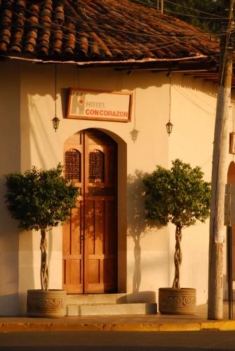 two trees in front of a building with a door at Hotel con Corazón Granada in Granada