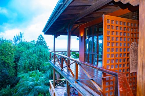 a building with a wooden staircase leading to a balcony at Villa Vanilla in Port Glaud