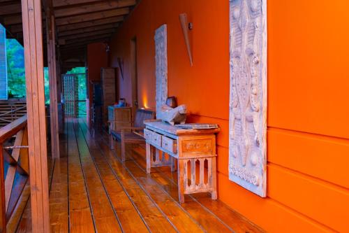 an orange room with a wooden floor and a table at Villa Vanilla in Port Glaud