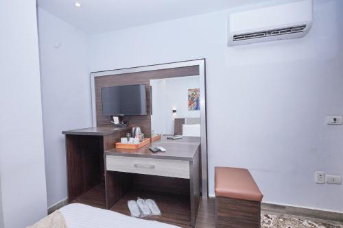 a room with a desk with a tv and a mirror at Kayan Pyramids View in Cairo