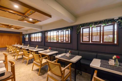 a row of tables and chairs in a restaurant at Villa Kayu Raja in Seminyak