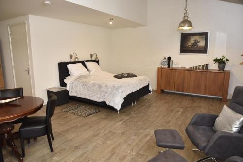 a bedroom with a bed and a table and chairs at Munnickenheide Buitengewoon Overnachten in Terheijden