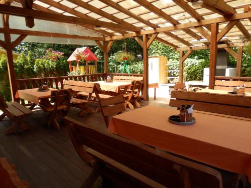 a restaurant with wooden tables and wooden chairs at Penzion Janoštík in Rožnov pod Radhoštěm