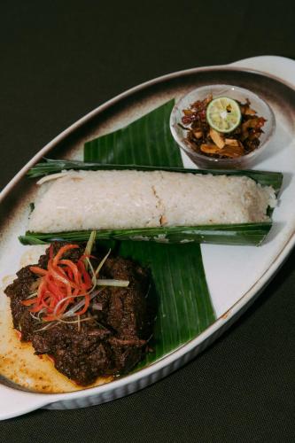 a plate of food with a sandwich on a banana leaf at Villa Kayu Raja in Seminyak