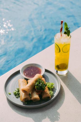 a plate of food and a drink on a table at Villa Kayu Raja in Seminyak