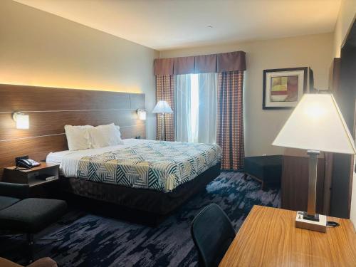 a hotel room with a bed and a desk at Rodeway Inn & Suites in Winnfield