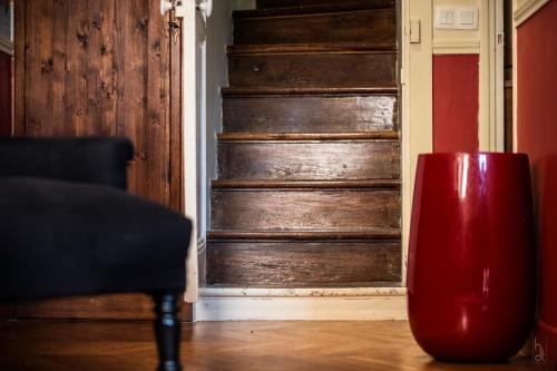 a red vase sitting in front of a wooden door at Le Clos Tellier in Mareil-Marly