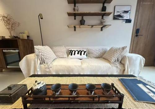 a living room with a white couch and a table at M Country Road 山行野奢影院温泉民宿 in Dujiangyan